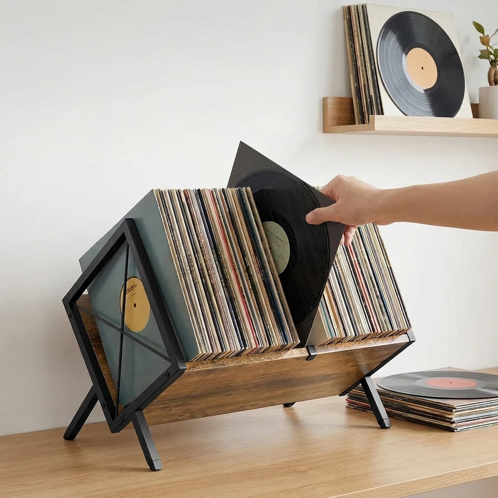 Une main sort un vinyle du support posé sur un meuble, les pochettes voisines restent en place